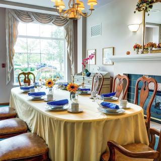 A beautifully set dining table in a well-lit room with elegant decor and sunflowers as a centerpiece.