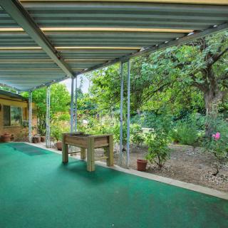 A tranquil patio area overlooking a lush garden with abundant greenery.