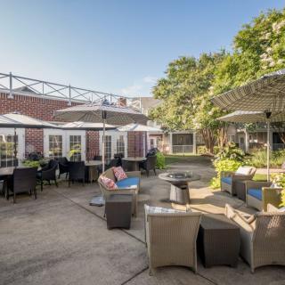 A spacious outdoor patio with comfortable seating and shade umbrellas on a sunny day.