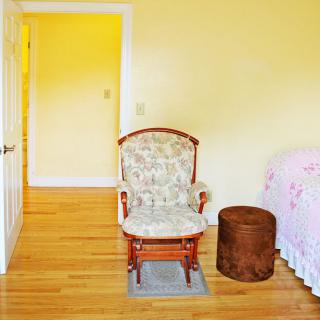 A cozy bedroom featuring a rocking chair and elegant interior design.