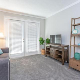 A cozy and modern living room featuring a comfortable seating area, elegant shelving, and ample natural light.