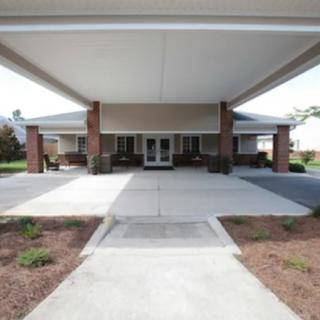 A covered entrance to a building with a wide driveway.