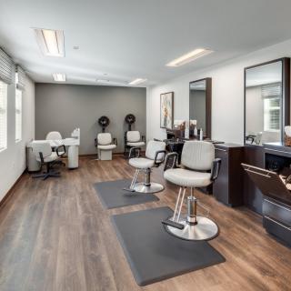 A modern hair salon interior with stylish chairs and mirrors.