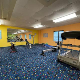 A vibrant gym space equipped with various fitness machines, perfect for a workout session.