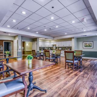 A spacious dining area with wooden floors and modern lighting.