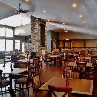 An empty restaurant dining area with neatly arranged tables and chairs.
