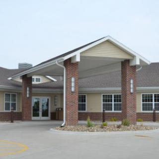 A modern residential building featuring a welcoming entrance with columns and large windows.
