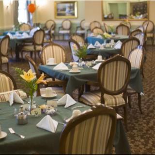 An elegant dining area with neatly arranged tables and chairs, featuring decorative table settings.