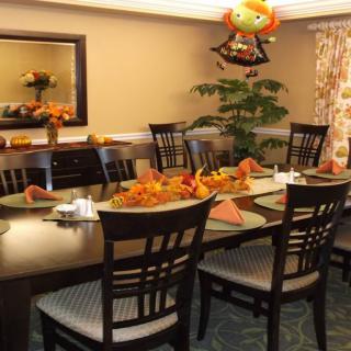 A dining room decorated for an autumn holiday, featuring a table set with festive decorations.