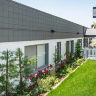 A modern house with a well-maintained garden and lush green lawn.