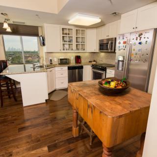 A modern kitchen with stainless steel appliances and wooden flooring.