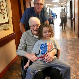 A heartwarming moment shared between three generations in a hospital hallway.
