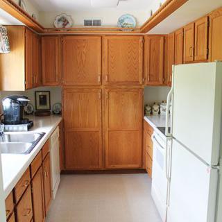 A kitchen with wooden cabinets, a refrigerator, and countertop appliances.