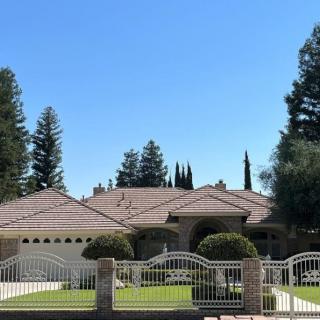 A suburban house with a gated front yard and well-maintained landscaping.