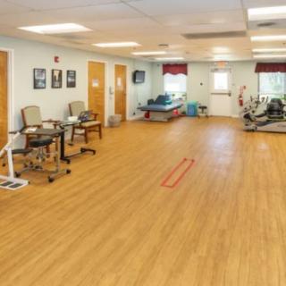 A spacious rehabilitation therapy room equipped with various exercise machines and equipment.