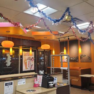 A vibrant fast food restaurant interior decorated with colorful streamers.