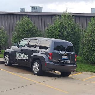 A parked SUV branded with a business logo in an urban setting.