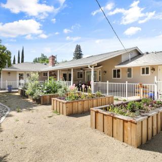 A spacious backyard with planter boxes under a clear blue sky.