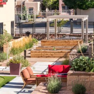 A well-designed garden with raised beds and stylish outdoor seating in an urban setting.