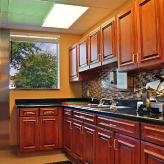 A kitchen with wooden cabinets and a large window providing natural light.