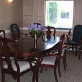 A cozy dining room with a polished wooden table and chairs, complemented by a window view.