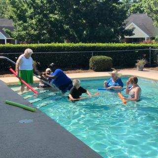 A group of people enjoying a sunny day at the pool.