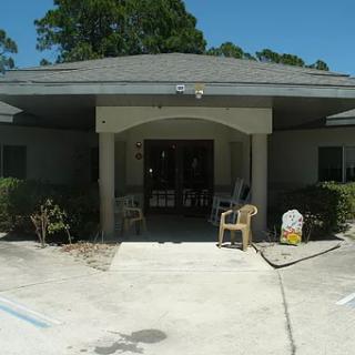 The entrance of a building with chairs and a small porch area.