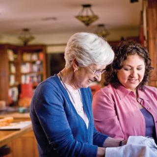 Two women enjoying a conversation in a cozy kitchen setting.
