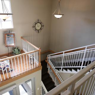 A spacious and well-lit staircase area with wooden railings and decorative elements.
