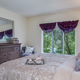 A cozy bedroom with elegant drapes and a large mirror reflecting the room's decor.