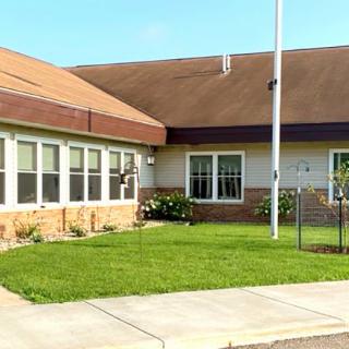 A suburban building with a well-maintained lawn and a flagpole in front.