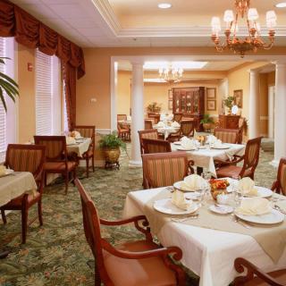A well-decorated dining room with neatly arranged tables, chairs, and elegant decor.