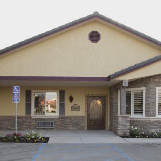 A suburban residential building with a stone facade and a well-maintained entrance.