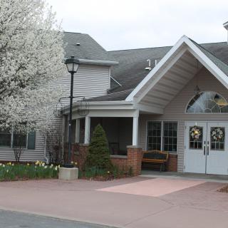 A residential building with a peaked entrance and blooming trees.