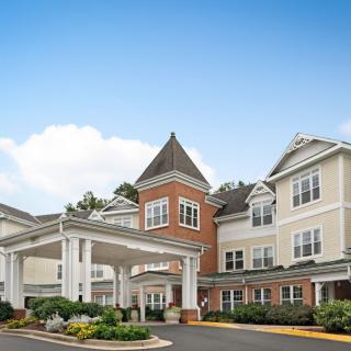 A large residential building with a prominent entrance under a clear sky.