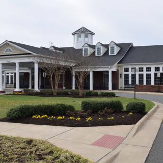 A well-maintained building with a landscaped garden and driveway.