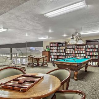 A cozy recreational space featuring bookshelves, a pool table, and a seating area for games or reading.