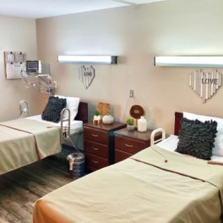 A well-organized hospital room with two beds and medical equipment.