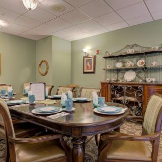 An elegantly set dining room with classical furniture and decorative plates.