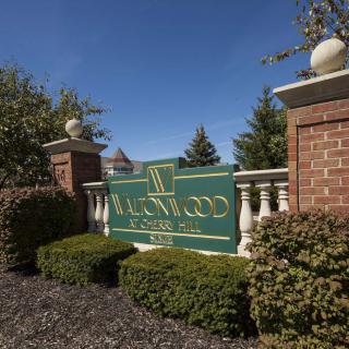 Entrance sign to Ravenwood Club Estates surrounded by landscaping and brick pillars.