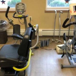 A small fitness area with exercise equipment including a stationary bike and other workout machines.