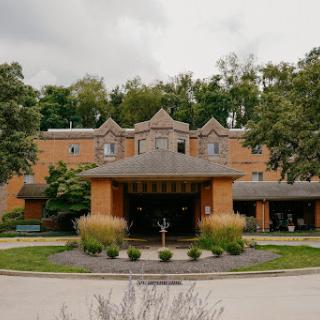 A beautifully designed building surrounded by lush greenery.
