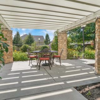 A beautiful garden patio with a pergola providing shade over an outdoor dining set.