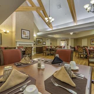 An elegantly set dining room with neatly arranged tables and chairs, ready for guests.