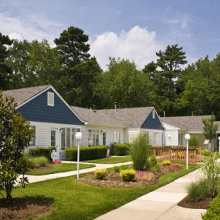 A well-maintained suburban residential area with landscaped gardens and connected pathway.