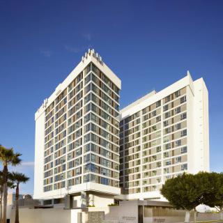 A modern hotel building under a clear blue sky.