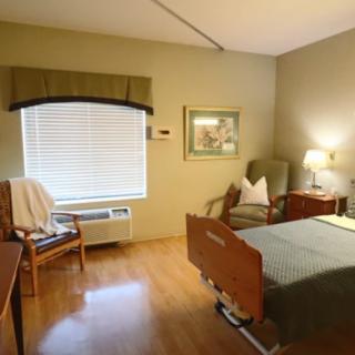 A cozy room with a hospital bed, wooden furniture, and soft lighting.