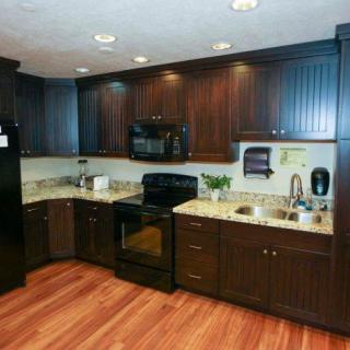Modern kitchen with dark wood cabinets and appliances.