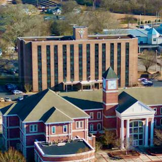 Aerial view of a distinctive architectural complex featuring a hotel and adjacent building with a clock tower.