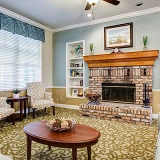 A cozy living room with a brick fireplace and classic decor.